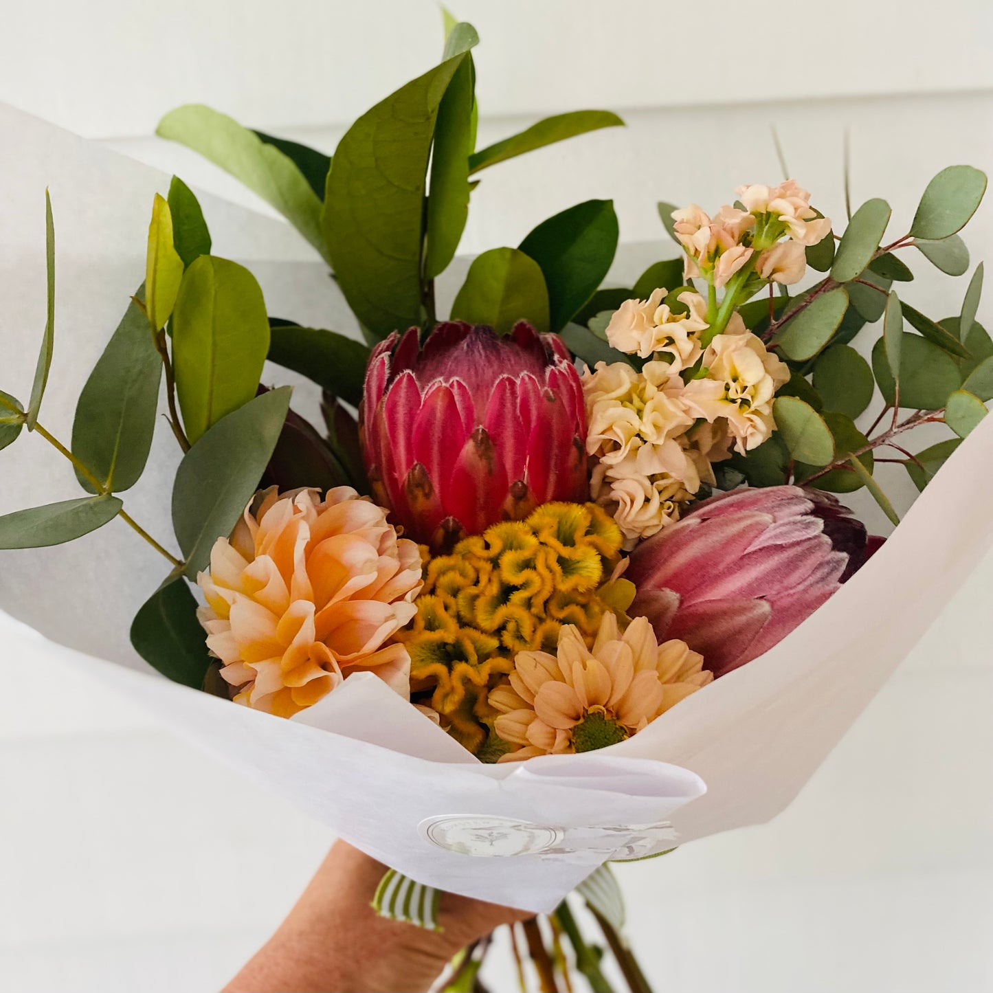 A mixed posy with a small Robert Gordon shopping bag